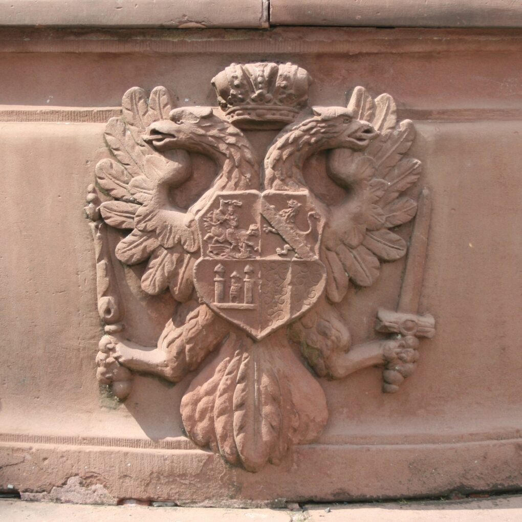 The coat of arms of the castle with a double-headed eagle in the background