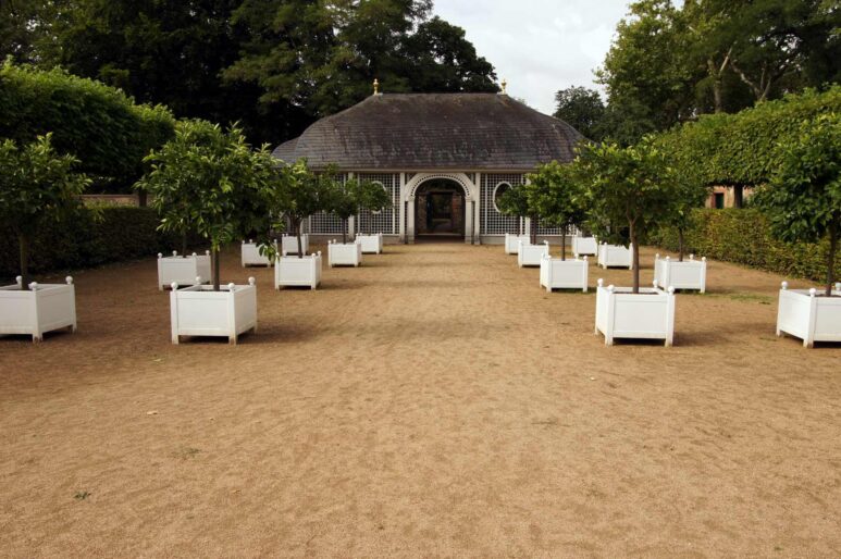 The square in front of the tea house. Four rows of planted white tubs can be seen.